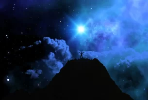 um homem no topo da montanha a luz da lua