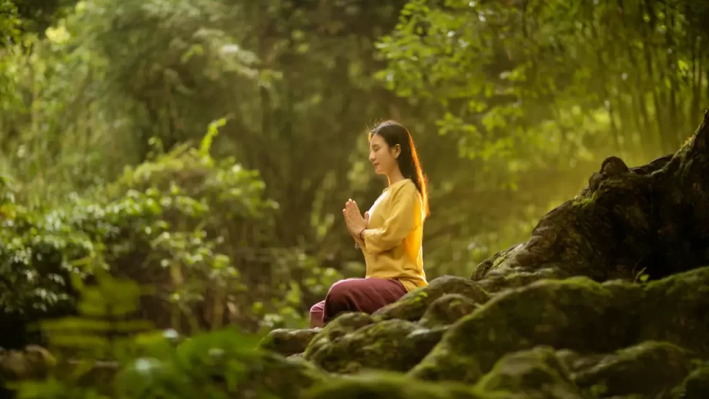 mulher meditando na floresta