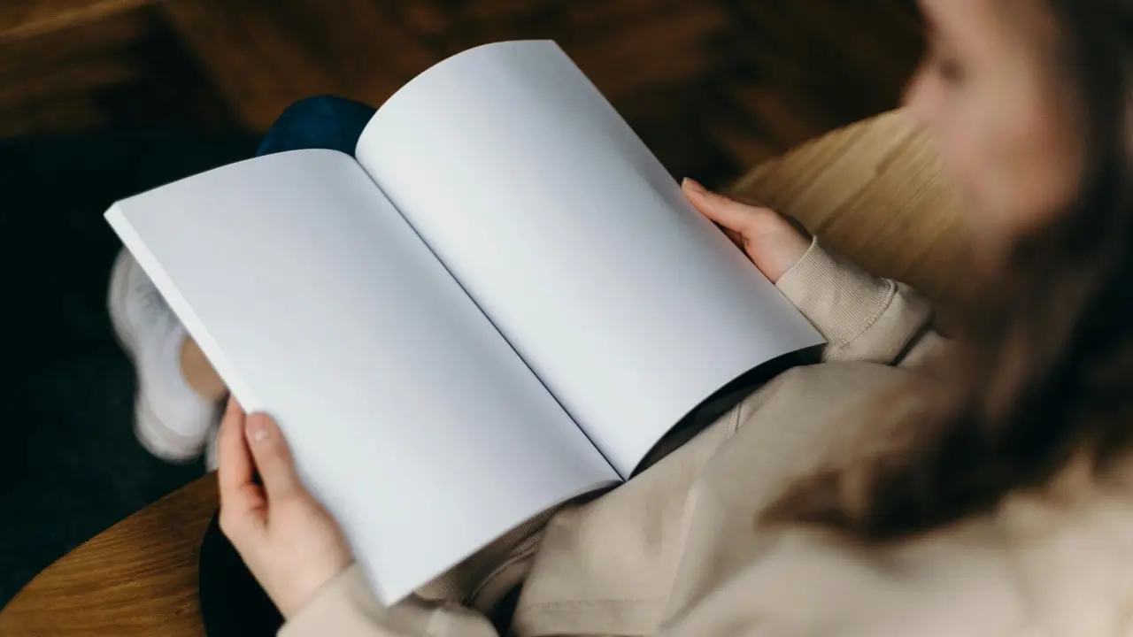 Mulher sorrindo enquanto segura um livro em branco, representando o poder de escrever sua própria história e assumir sua transformação pessoal.” melhor livro de autoajuda do mundo