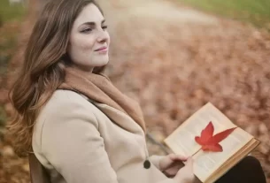 mulher sentada em uma praça lendo o melhor livro de autoajuda do mundo