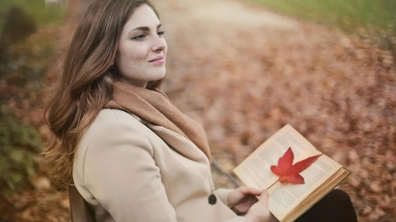 mulher sentada em uma praça lendo o melhor livro de autoajuda do mundo