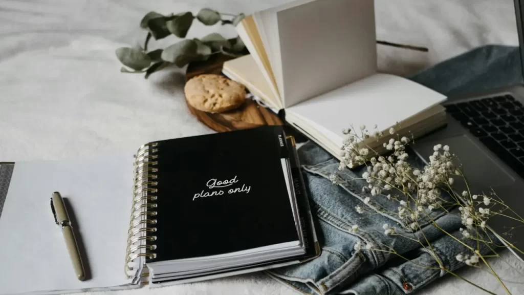 Livro ou caderno aberto com páginas em branco e uma caneta, simbolizando que cada pessoa é autora da própria vida e criadora de sua jornada de autoconhecimento.”