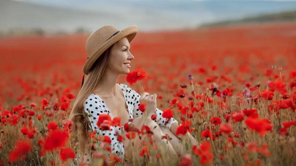 mulher em um campo de flores vermelhas