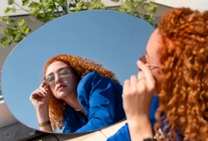 mulher se olhando no espelho pensando em como aumentar sua autoconfiança