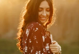 Mulher praticando autocuidado em meio à natureza com expressão de paz interior em 2025. práticas de autocuidado