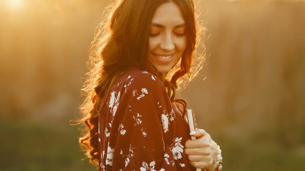 Mulher praticando autocuidado em meio à natureza com expressão de paz interior em 2025. práticas de autocuidado