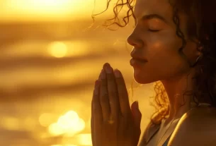 Mulher de braços abertos sentindo gratidão ao nascer do sol em meio à natureza a manifestar prosperidade.