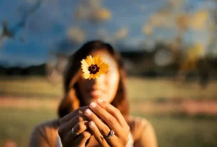 “Mulher libertando uma borboleta como símbolo de transformação, mostrando como o perdão se torna um ato de autocuidado.”