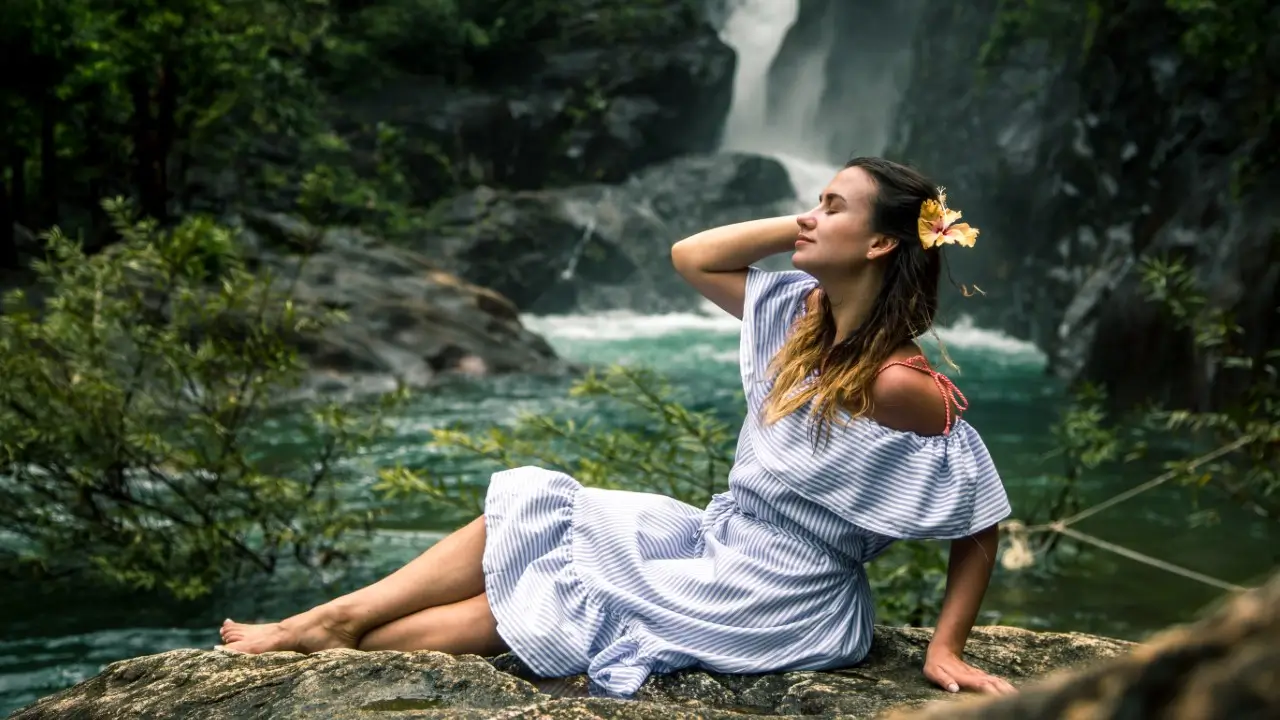 mulher sentada a beira da cachoeira sentindo reconexão com o Sagrado Feminino: A Memória da Alma