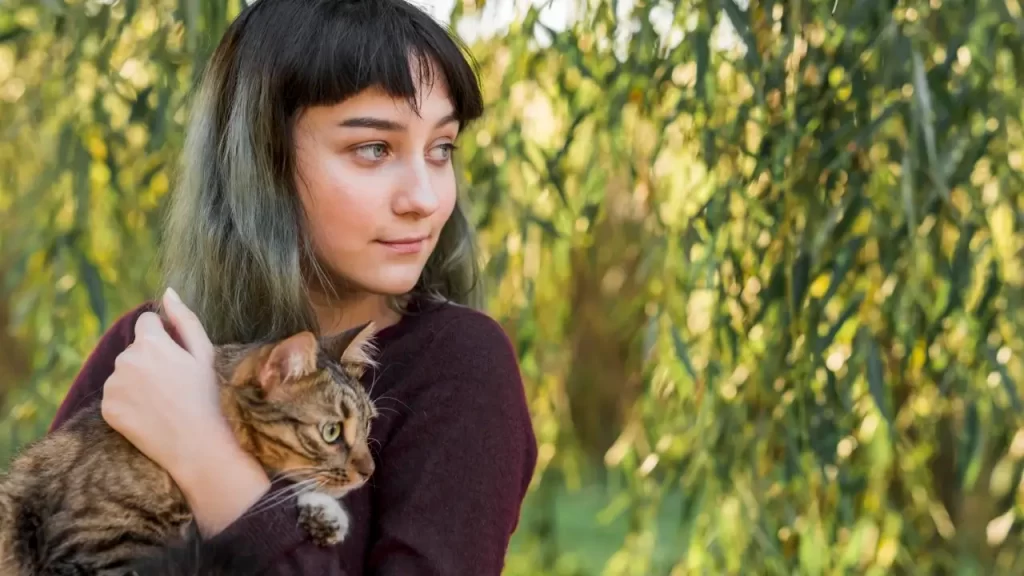 Gato repousando sobre o peito de uma mulher, simbolizando cura energética e amor incondicional.