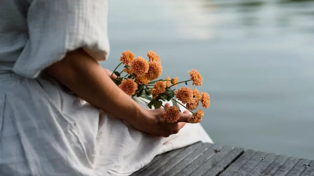 mãos femininas segurando ramo de flores  simbolizando  cura interior com a hipnose clinica